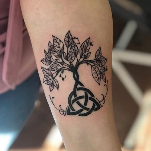 Celtic Triquetra knot tattoo on shoulder, symbolizing unity and eternal family connection.