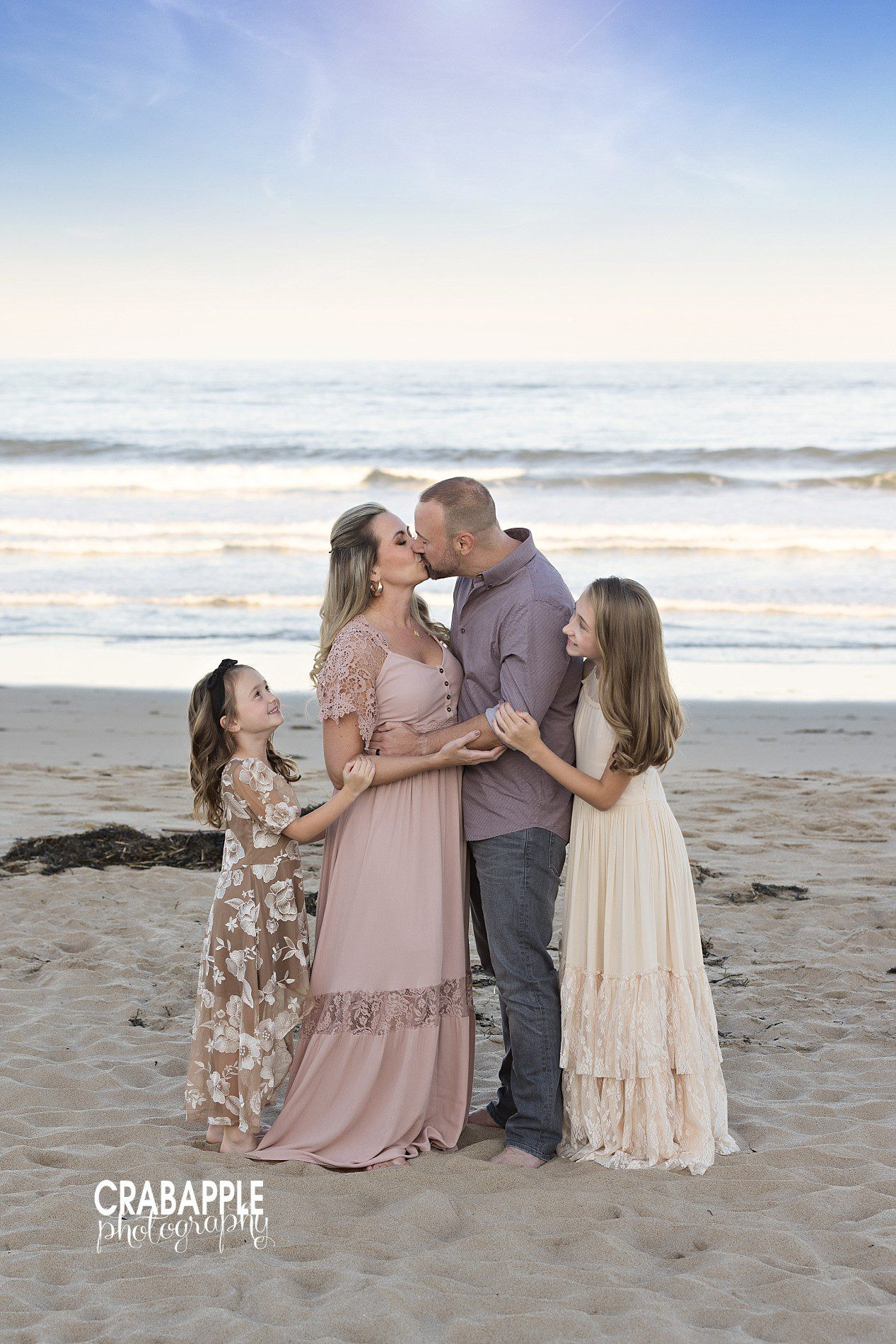 Family photos with parents kissing in fall setting