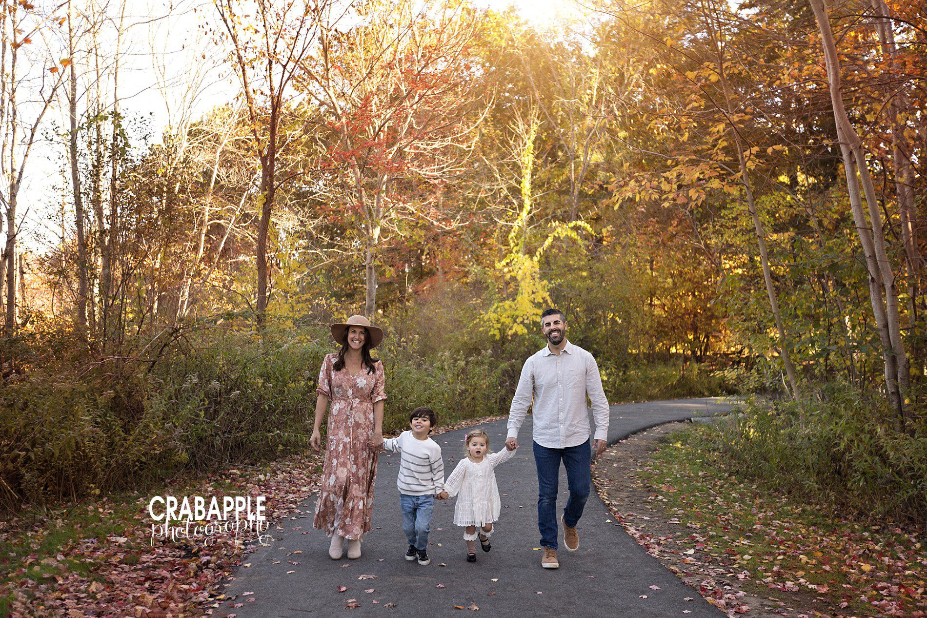 Fall family photos with walking pose amidst foliage