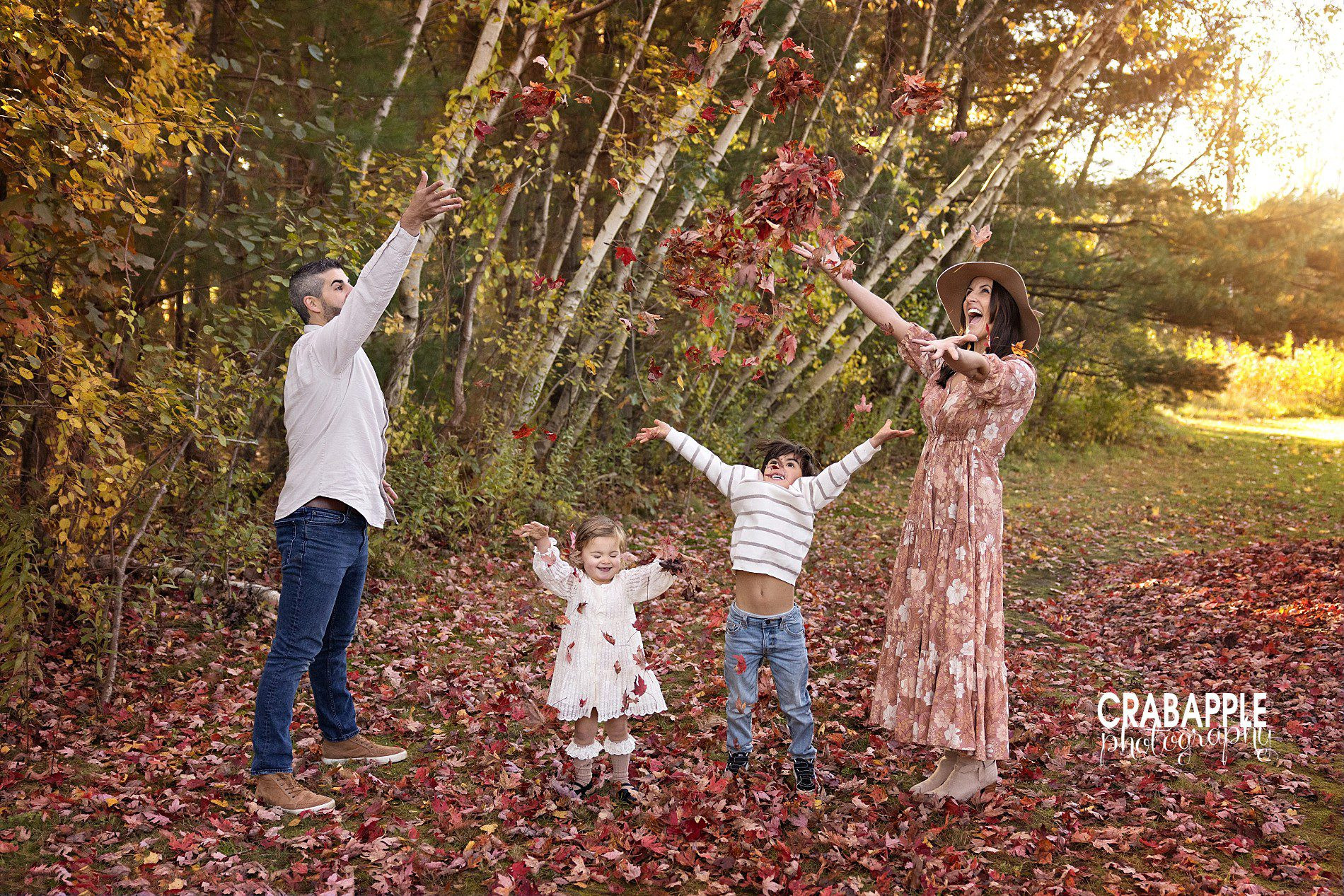 Family pictures throwing leaves in fall