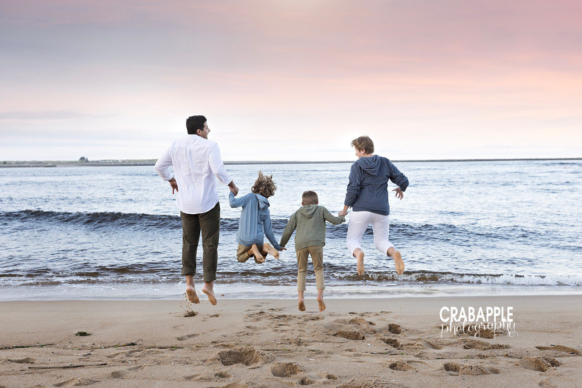 Fun family photos jumping in the air on beach, adaptable for fall