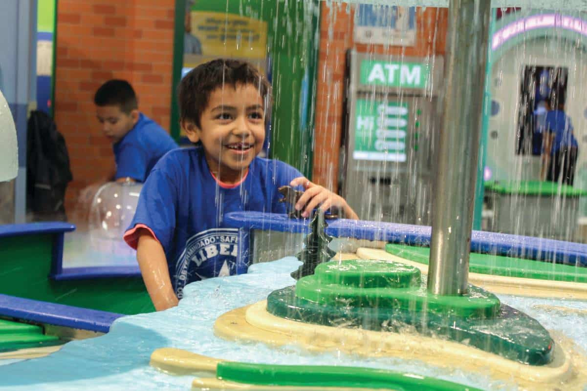 Child playing with water exhibit at the Omaha Children's Museum