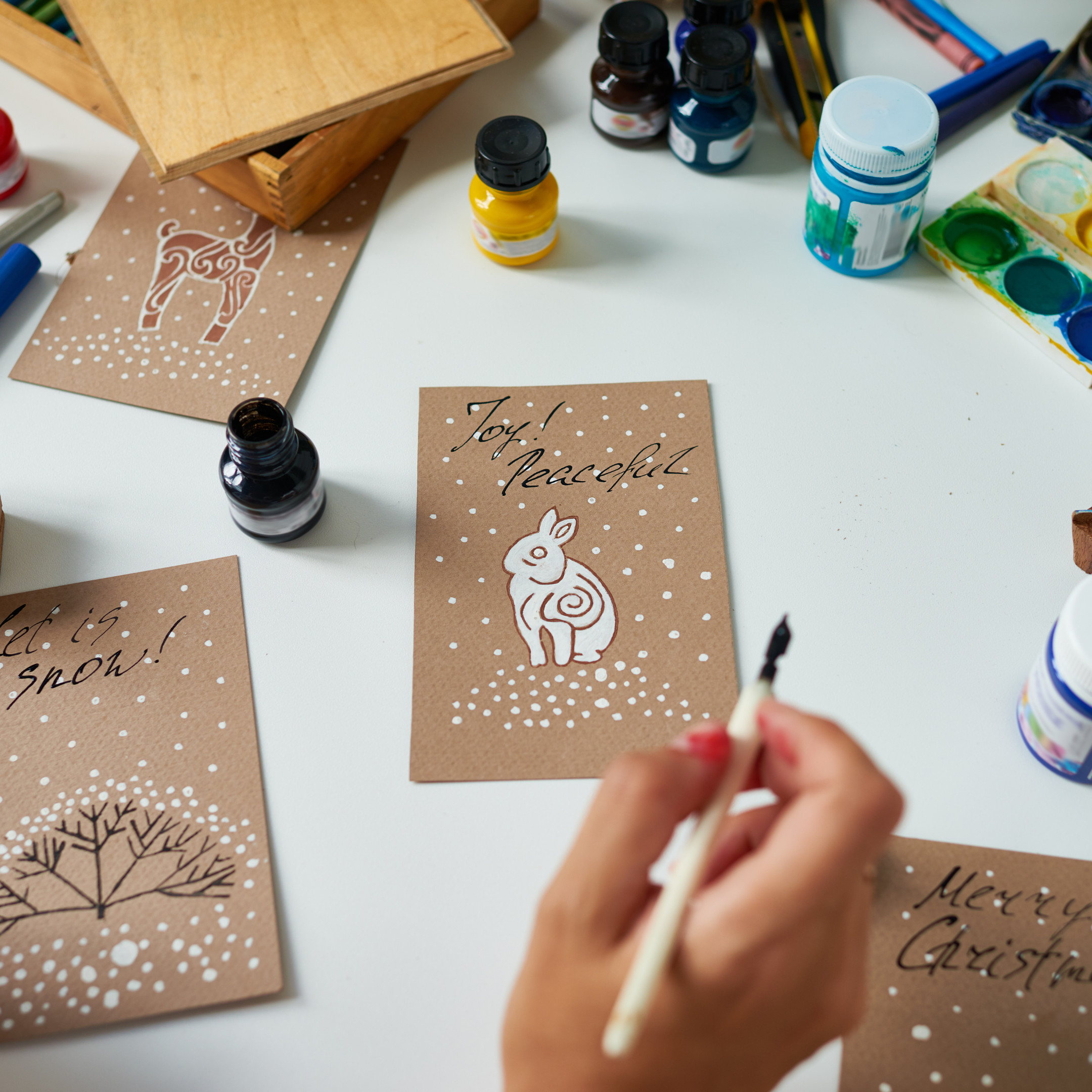 A creatively crafted homemade Christmas card featuring a white bunny in a snowy scene, conveying a warm and personal holiday greeting.