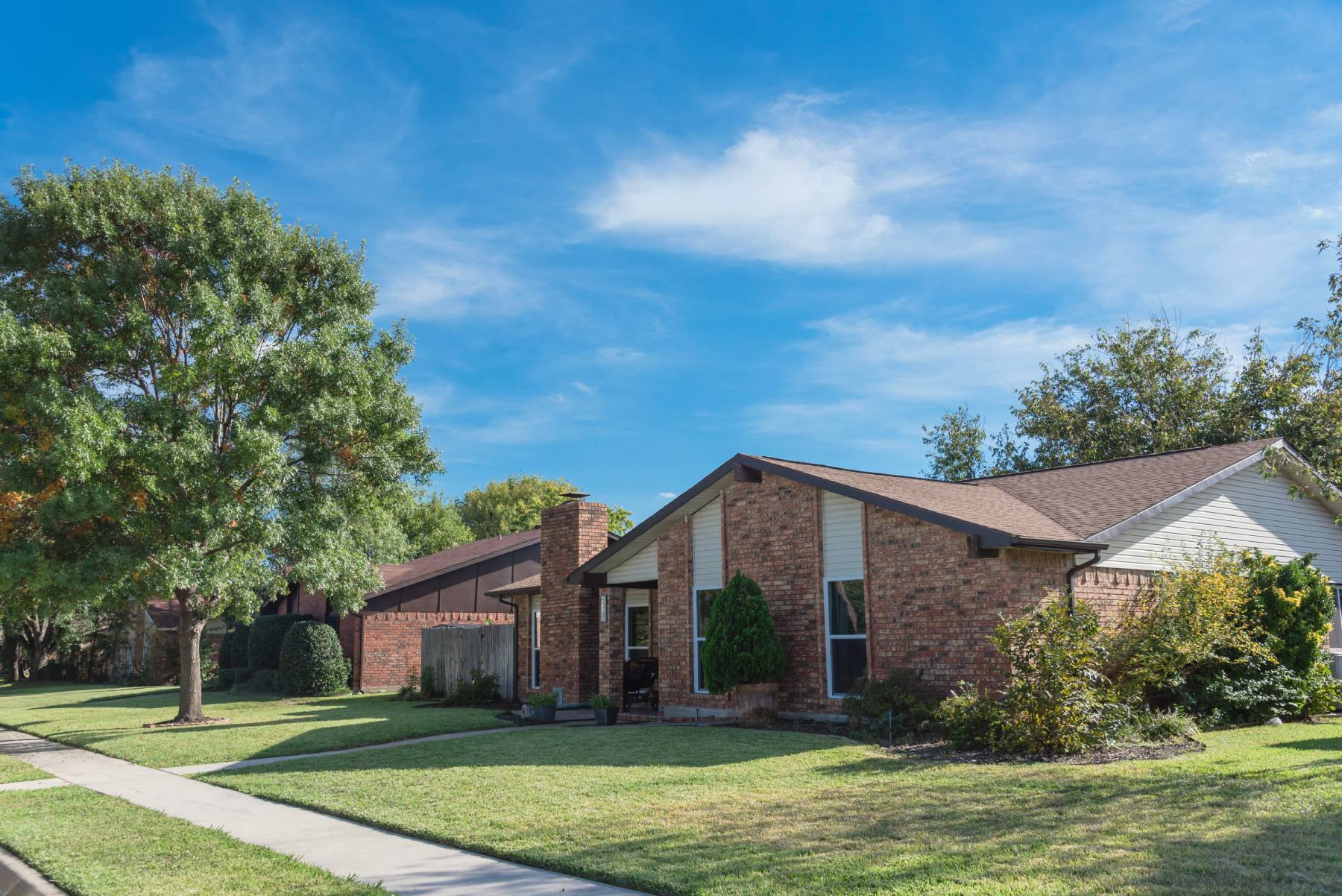Exterior of a detached family home showcasing a yard and landscaping