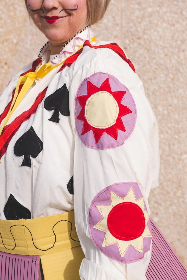 Brittany wearing a blouse with puffy sleeves and fabric embellishments, part of her detailed knight Alice in Wonderland costume.