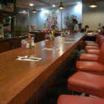 Retro interior of Astro Family Restaurant with orange booths and counter seating