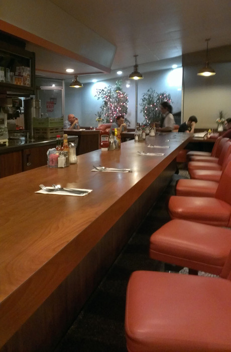 Retro interior of Astro Family Restaurant with orange booths and counter seating
