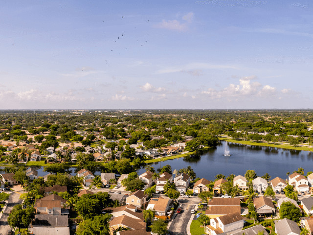 Aerial view of Weston, Florida, with rooftops and lakes, showcasing suburban affluence and planned community living for families in Southeast Florida