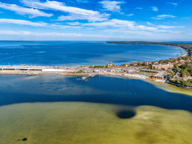 Aerial view of Gulf Breeze, Florida, showcasing coastline and waterfront homes, representing coastal living and outdoor activities for families in the Panhandle