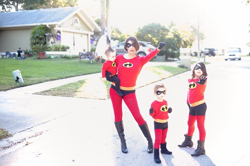 A child in a DIY Incredibles costume showing the orange duct tape belt detail, emphasizing the budget-friendly and no-sew approach to the family costume.