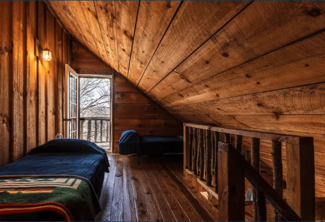 Loft area with beds in a wooden cabin at Earthshine Mountain Lodge