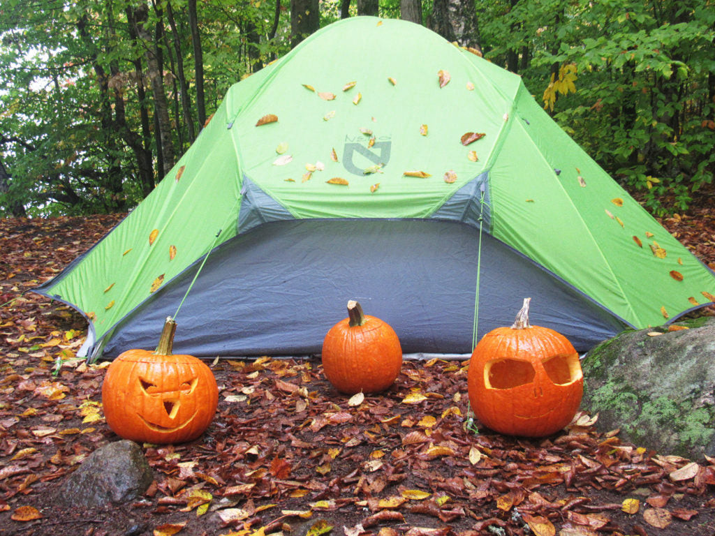 Family tradition of carving pumpkins while camping outdoors