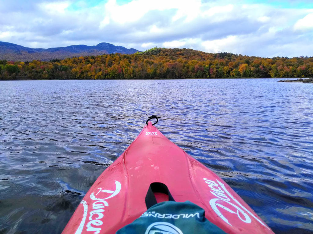 Family kayaking on a calm lake after a camping breakfast