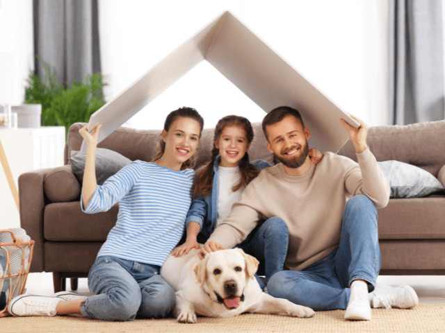 Family with dog holding cardboard boxes in Davenport, Florida, symbolizing moving and the family-friendly atmosphere of the city in Central Florida