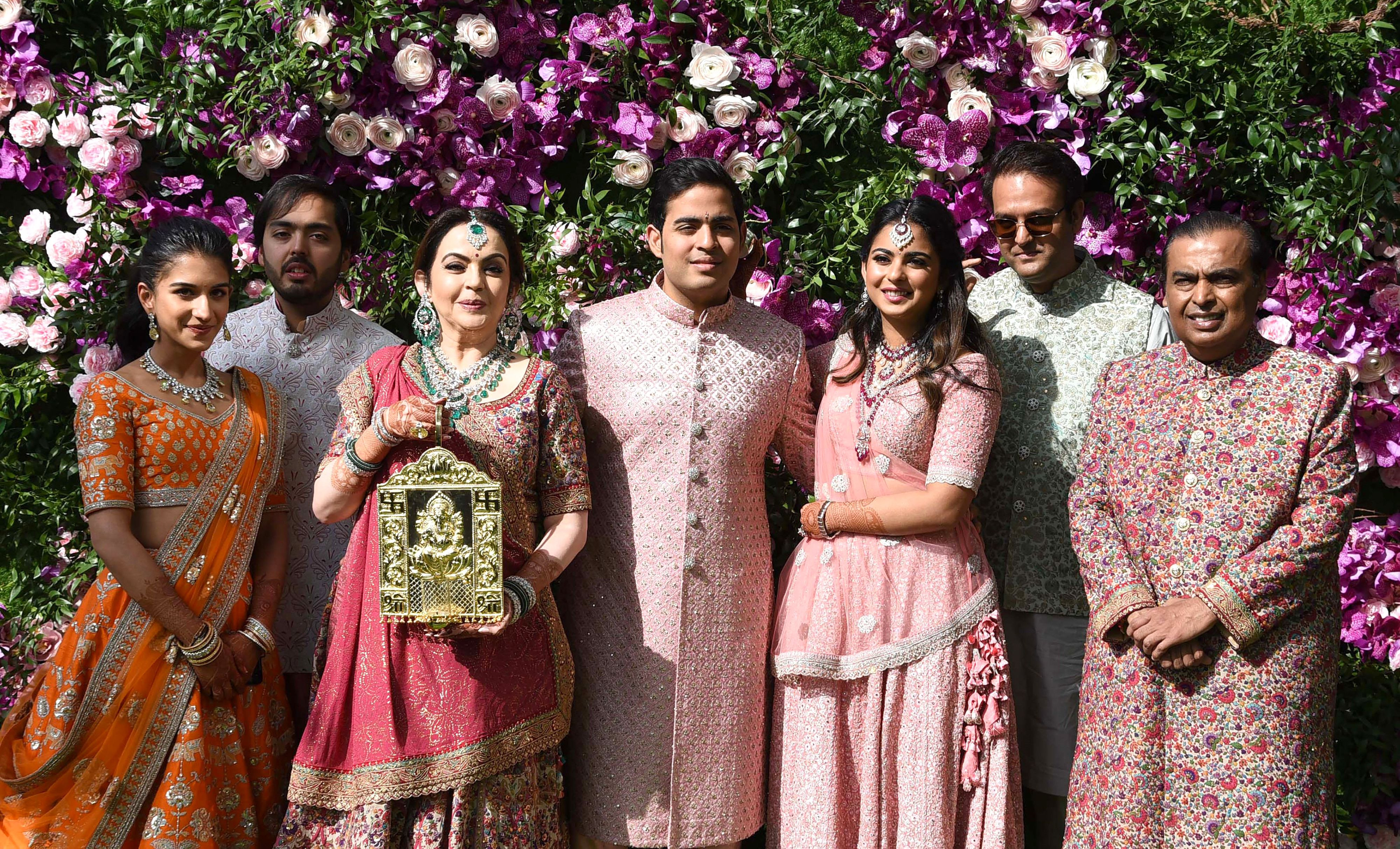 Mukesh Ambani with his family, including wife Nita Ambani and children Akash, Isha, and Anant Ambani, at his eldest son Akash's wedding, representing the family's unity and legacy of wealth.