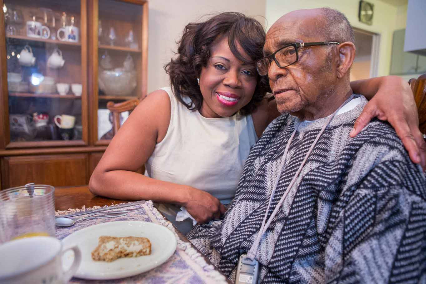 Woman assisting elderly man with meal - Family Caregiver Alliance support for daily caregiving