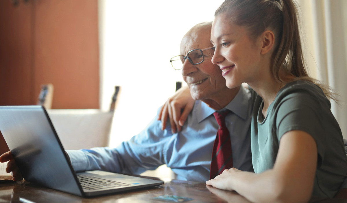 A German grandfather enjoys a video call with his granddaughter, connecting with family online.