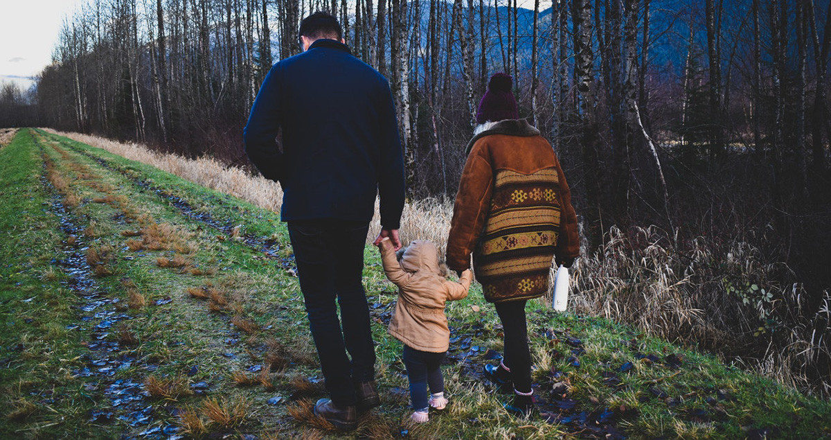 A young boy enjoys a walk in the German forest with his parents and sister, showcasing family time in Germany.