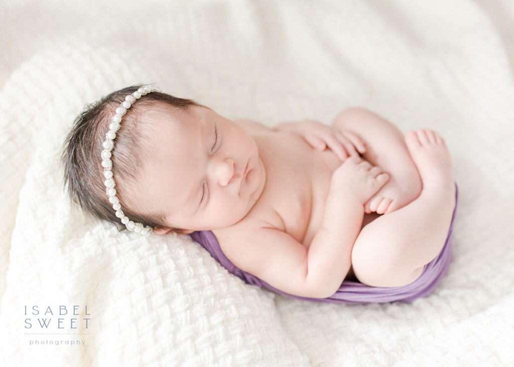 A close-up shot of a swaddled newborn baby's face, highlighting peaceful sleep and comfort.