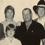 The patriarch of the Von Erich wrestling family, Fritz Von Erich, standing proudly in a wrestling ring, showcasing his powerful physique and commanding presence.