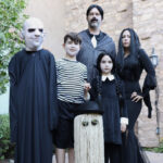 Family dressed as The Addams Family, including Wednesday, Pugsley, Morticia, Gomez, Fester, and Cousin Itt