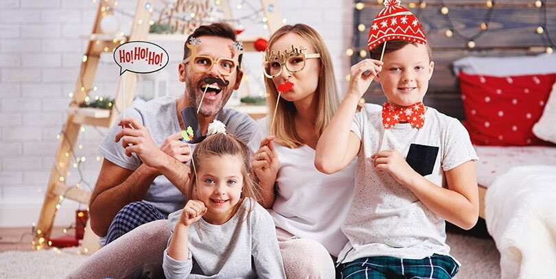 Family playing Christmas charades, laughing and having fun, adding to the festive atmosphere.