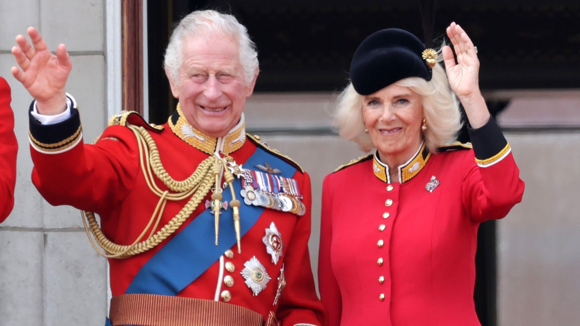 King Charles III and Queen Camilla waving from the Buckingham Palace balcony