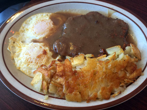 Chicken Fried Steak with Brown Gravy, Hashed Browns, Two Eggs and a Pancake at Loyola's Family Restaurant.