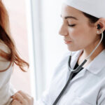 A doctor talking to a patient and taking notes during a consultation at a family medical center