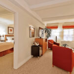 San Carlos Hotel Family Suite Alt Text: A spacious living area in the San Carlos Hotel, featuring comfortable seating and a well-lit ambiance, perfect for families visiting NYC.