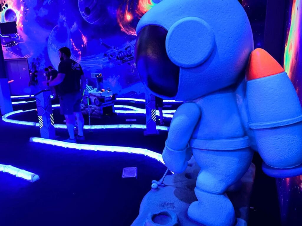 Affordable Black Light Mini Golf at Elev8 Orlando Sanford, featuring a space-themed indoor setting