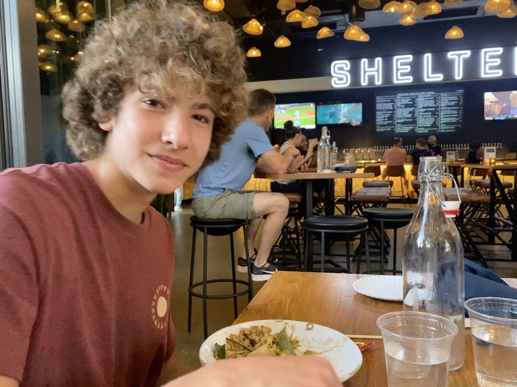 A father helps his daughter choose from a colorful menu at a family-friendly restaurant.
