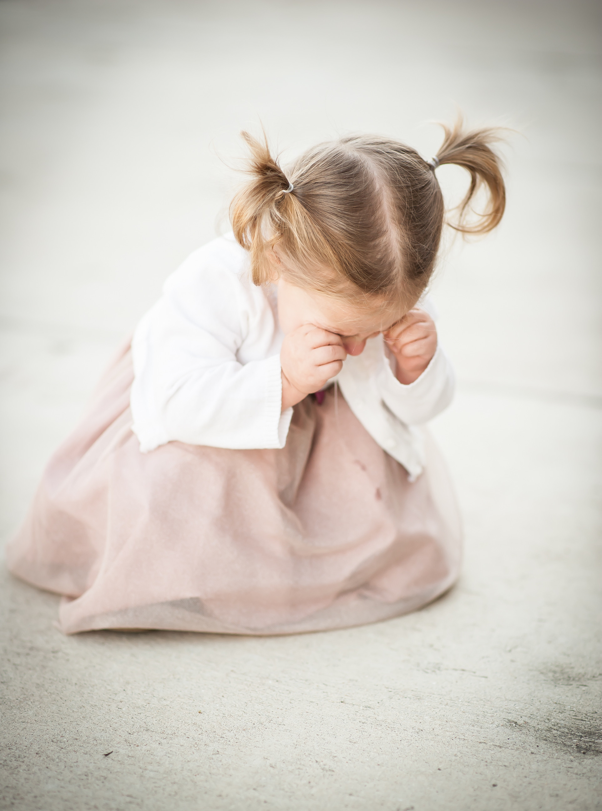 Candid family photoshoot showing a child in toddler meltdown mode, emphasizing that even imperfect moments can be cherished.